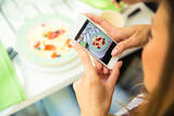 © DeanDrobot / iStock / Thinkstock Frau fotografiert mit dem Handy ihr essen. © DeanDrobot / iStock / Thinkstock