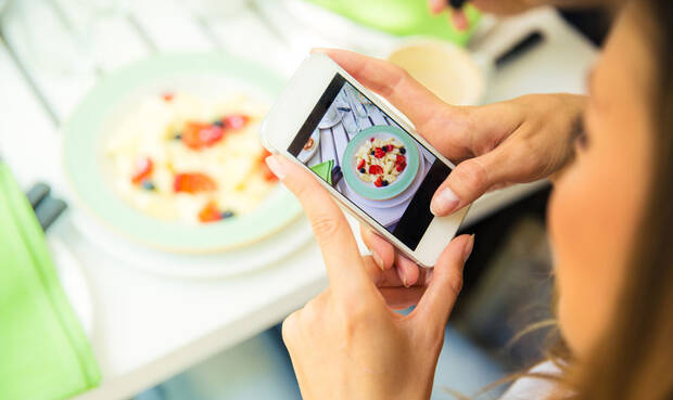 Frau fotografiert mit dem Handy ihr essen. © DeanDrobot / iStock / Thinkstock