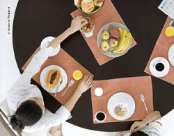 Kaufen und essen die Deutschen wirklich so bewusst, wie sie im Ernährungsreport angeben? Frau sitzt am Tisch und nimmt Erdbeere.
