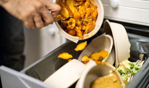 Nudeln werden von Teller in den Müll geschüttet.