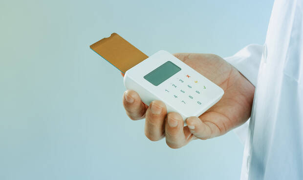 Kartenlesegerät wird in einer Hand gehalten