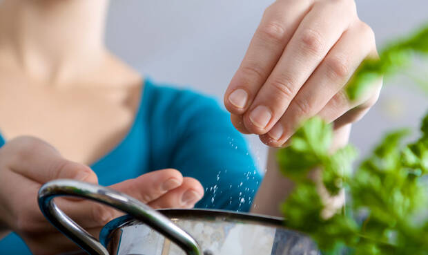 Frau wirft Salz in einen Topf. © DanielTaeger / iStock / Thinkstock
