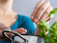 Frau wirft Salz in einen Topf. © DanielTaeger / iStock / Thinkstock
