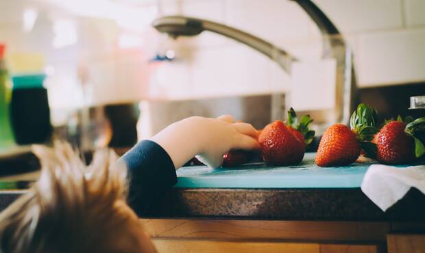 Kind greift nach Erdbeeren. Foto: Kelly Sikkema / Unsplash