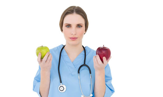 "Zum Anbeißen": Ärztin mit Äpfeln und Stethoskop. © Wavebreakmedia / iStock / Getty Images Plus