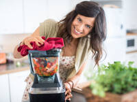 © julief514 / iStock / Thinkstock Frau bereitet Gemüse und Obst im Mixer zu.