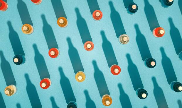 Cover des DGE-Positionspapiers Alkohol . Flaschen von oben mit langem Schatten